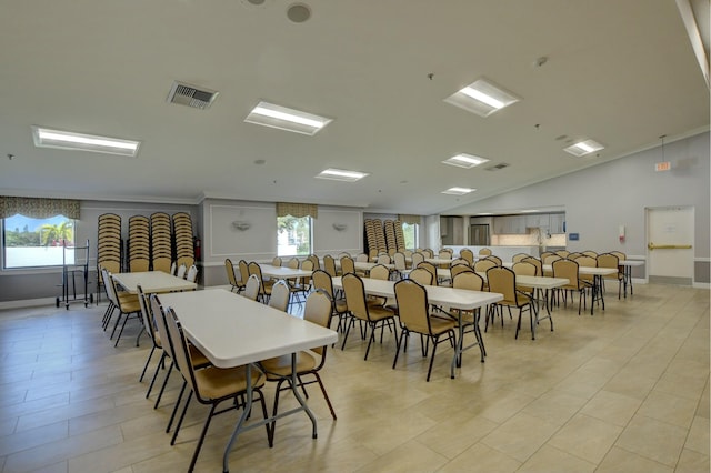 dining space with light tile patterned floors, a healthy amount of sunlight, and lofted ceiling