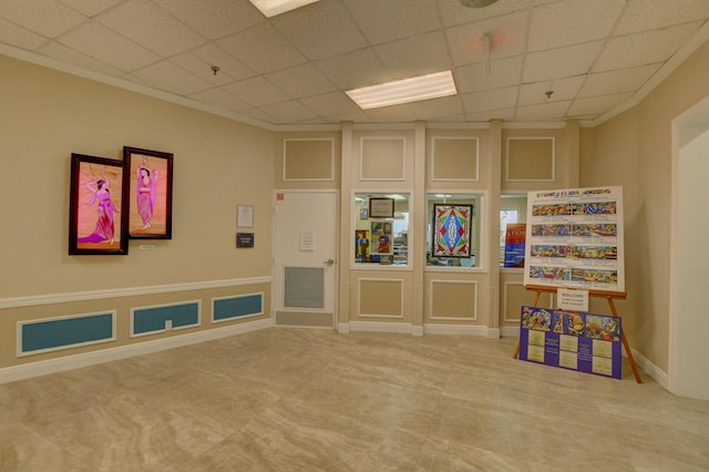 rec room with a drop ceiling and ornamental molding