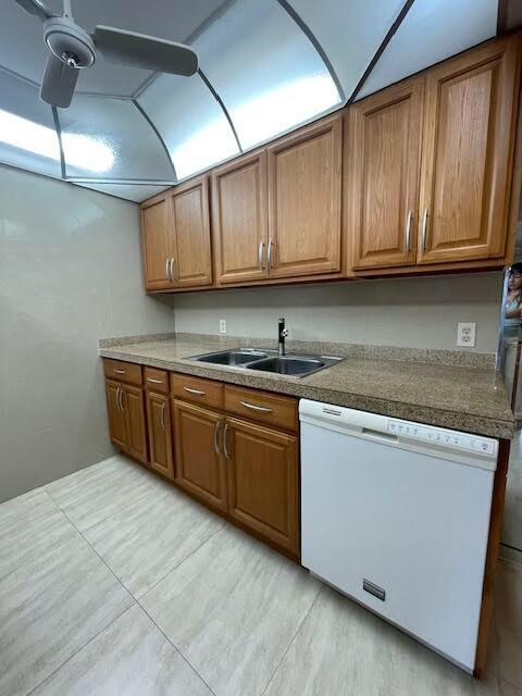 kitchen with dishwasher, light tile patterned floors, ceiling fan, and sink