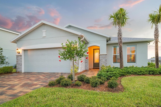 view of front of home featuring a garage and a yard