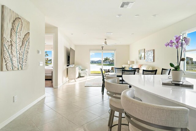 tiled dining space with ceiling fan and a healthy amount of sunlight