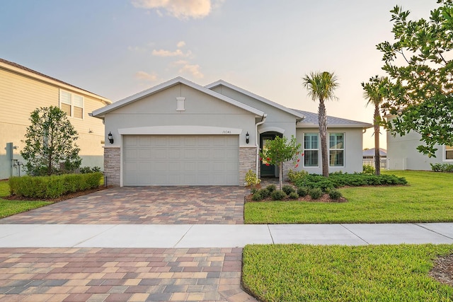 single story home with a garage and a lawn