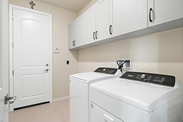 washroom featuring cabinets and separate washer and dryer