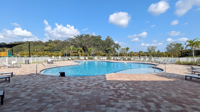 view of swimming pool with a patio and a water view