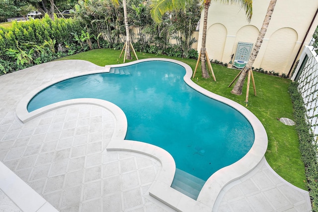 outdoor pool with a yard and a patio