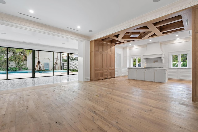 unfurnished living room featuring light hardwood / wood-style flooring, beamed ceiling, coffered ceiling, and ornamental molding