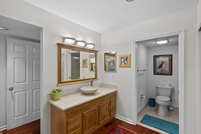 bathroom featuring vanity, toilet, and wood-type flooring