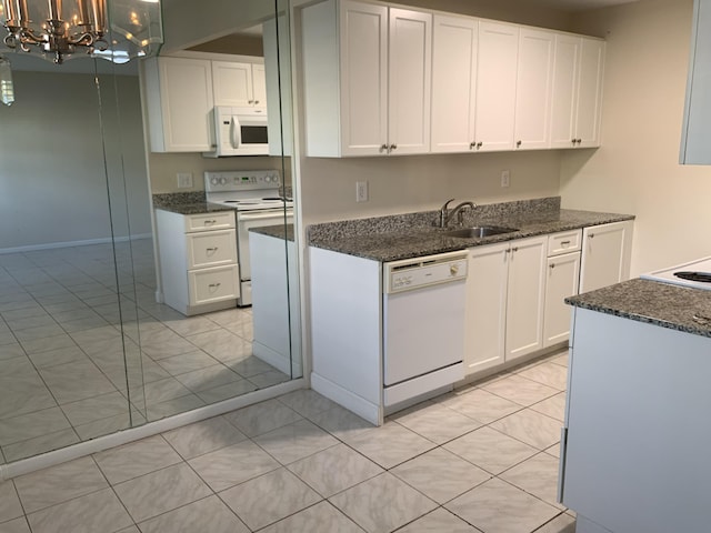 kitchen featuring white cabinets, white appliances, hanging light fixtures, and sink