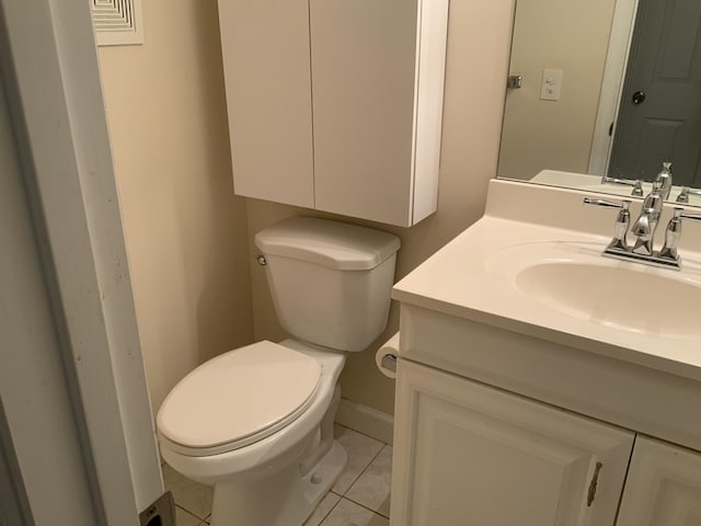 bathroom with tile patterned flooring, vanity, and toilet