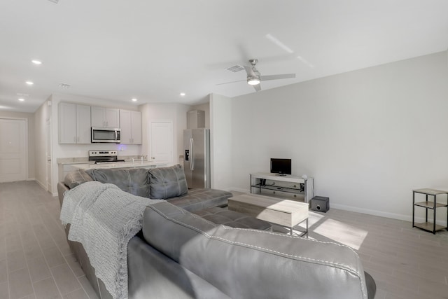 living room featuring ceiling fan and light hardwood / wood-style floors