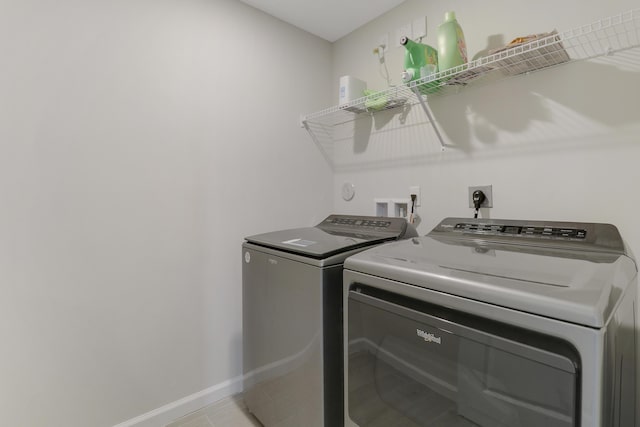 laundry area featuring washing machine and dryer and light tile patterned flooring