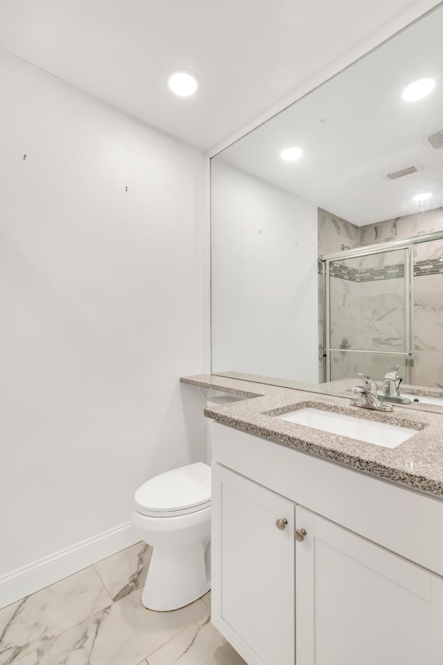 bathroom featuring vanity, toilet, and a shower with shower door