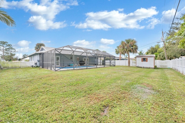 view of yard with a lanai, a fenced in pool, and a storage shed