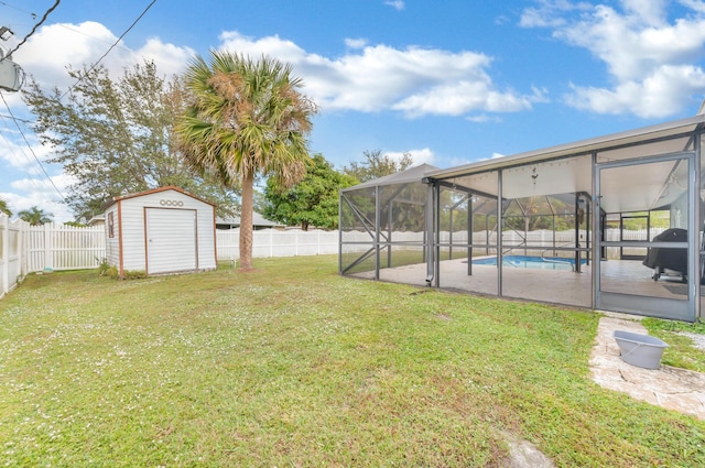 view of yard featuring a fenced in pool, glass enclosure, and a storage unit