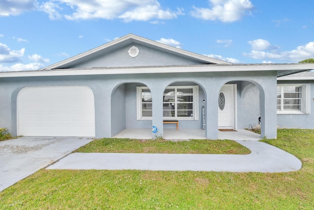 ranch-style house featuring a porch, a garage, and a front yard