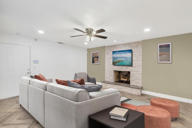 living room with ceiling fan, a fireplace, and light parquet floors