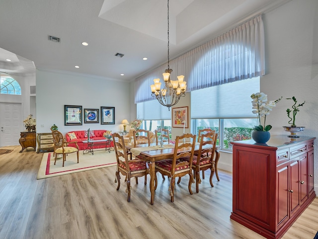 dining space with a notable chandelier, light hardwood / wood-style floors, and ornamental molding