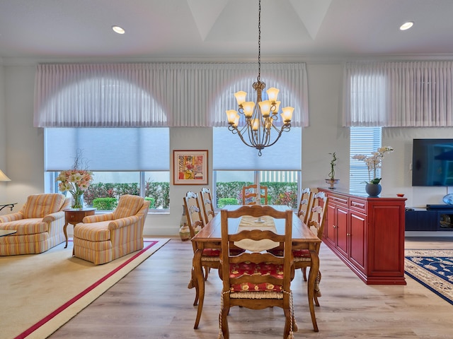 dining area with a chandelier, light hardwood / wood-style floors, and ornamental molding