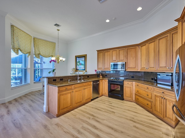 kitchen with decorative light fixtures, kitchen peninsula, ornamental molding, and appliances with stainless steel finishes