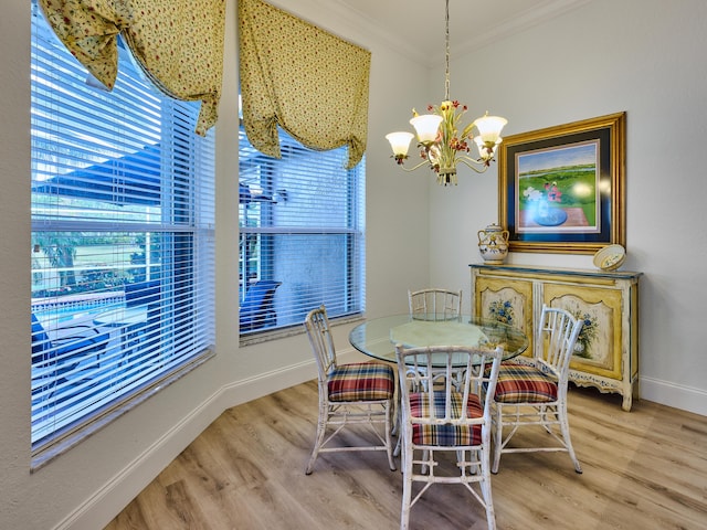 dining room with a healthy amount of sunlight, hardwood / wood-style flooring, ornamental molding, and a notable chandelier