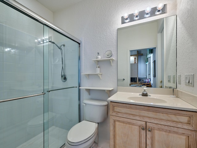 bathroom with vanity, toilet, and a shower with door