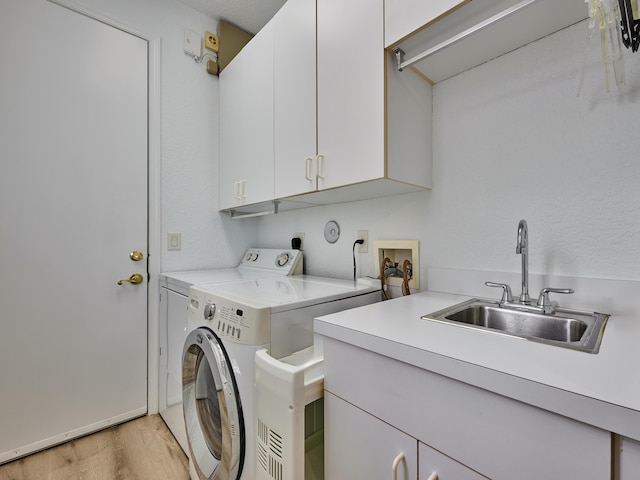 laundry room featuring cabinets, separate washer and dryer, light hardwood / wood-style flooring, and sink