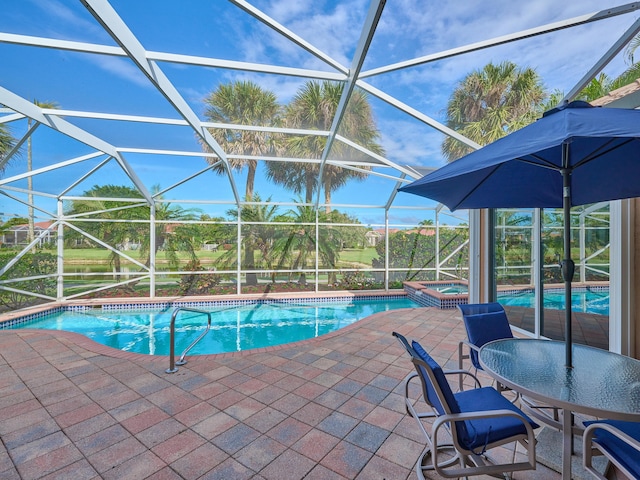 view of swimming pool with glass enclosure, an in ground hot tub, and a patio