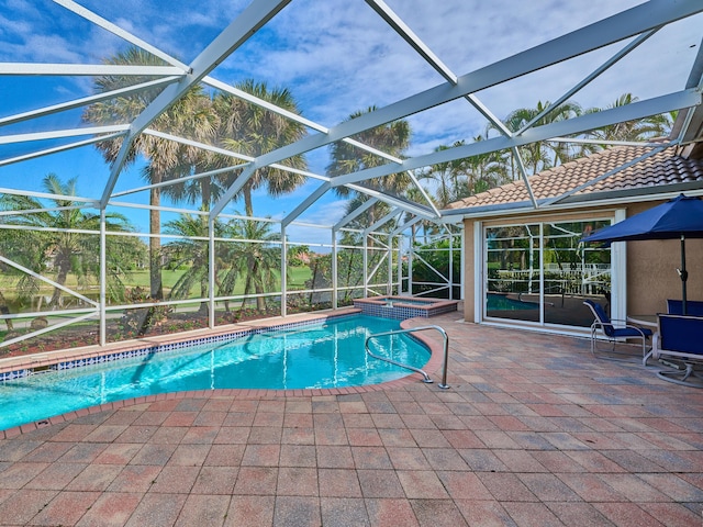 view of swimming pool featuring glass enclosure, a patio area, and an in ground hot tub