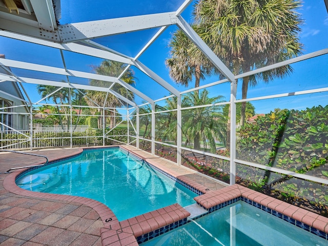 view of swimming pool featuring a lanai, a jacuzzi, and a patio