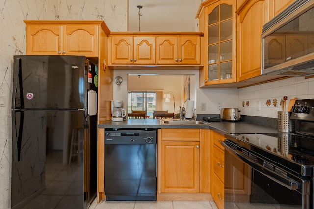 kitchen featuring sink, light tile patterned flooring, and black appliances