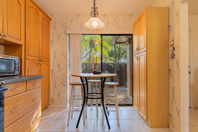 tiled dining room featuring a textured ceiling