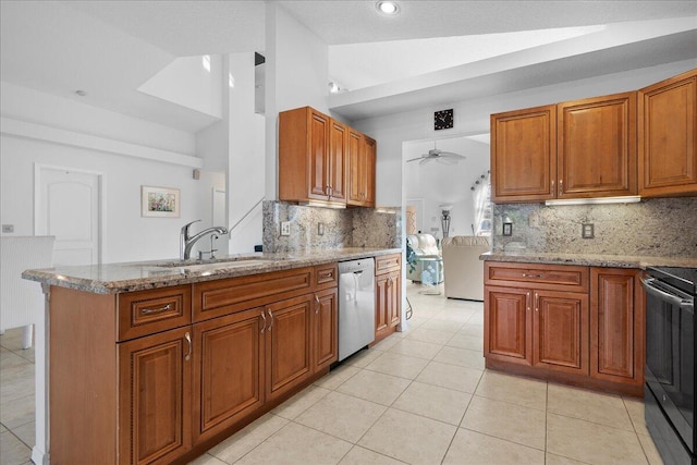 kitchen with decorative backsplash, light stone countertops, stainless steel appliances, and vaulted ceiling