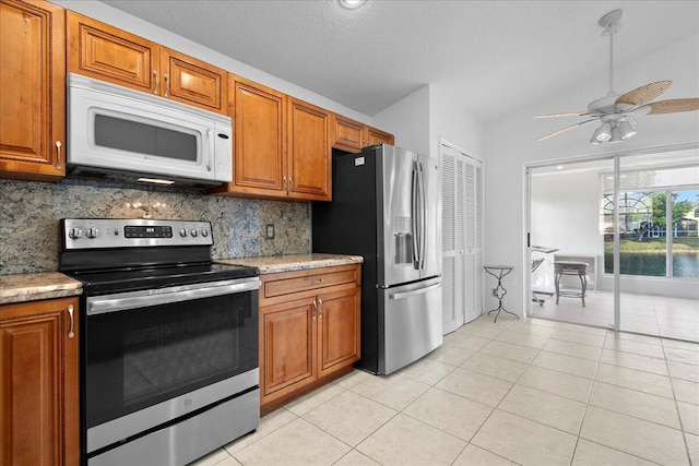 kitchen featuring decorative backsplash, appliances with stainless steel finishes, light tile patterned floors, and ceiling fan