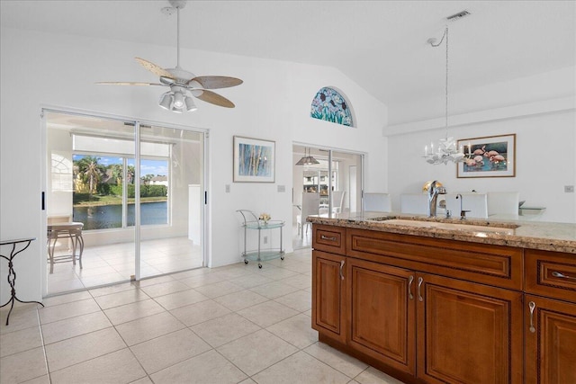 kitchen with sink, light tile patterned floors, pendant lighting, and ceiling fan with notable chandelier