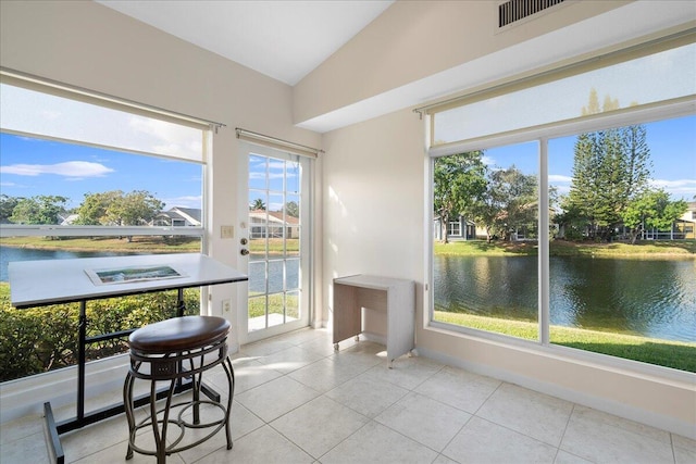 sunroom featuring a water view, a wealth of natural light, and vaulted ceiling