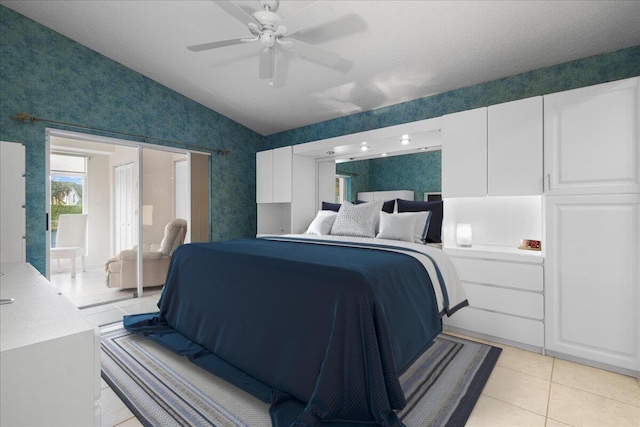 tiled bedroom featuring a textured ceiling, ceiling fan, and vaulted ceiling