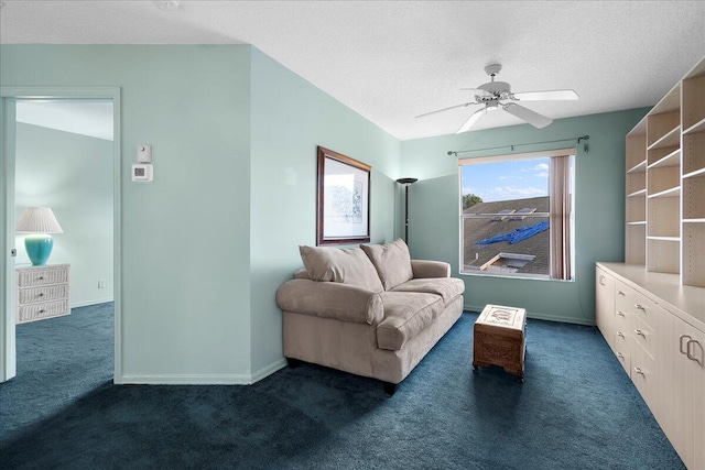 living room with ceiling fan, dark carpet, and a textured ceiling