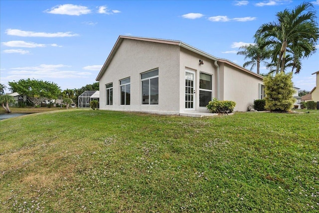 rear view of property featuring a yard and a lanai