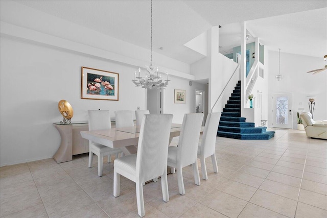 tiled dining space featuring a notable chandelier and high vaulted ceiling