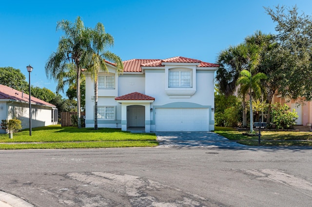 mediterranean / spanish house featuring a garage and a front lawn