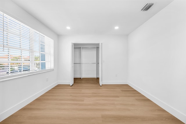 unfurnished bedroom with a closet and light hardwood / wood-style flooring