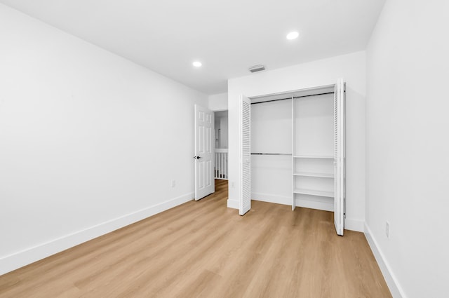 unfurnished bedroom featuring light hardwood / wood-style floors and a closet