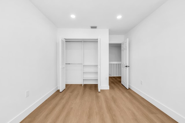 unfurnished bedroom featuring light hardwood / wood-style floors and a closet