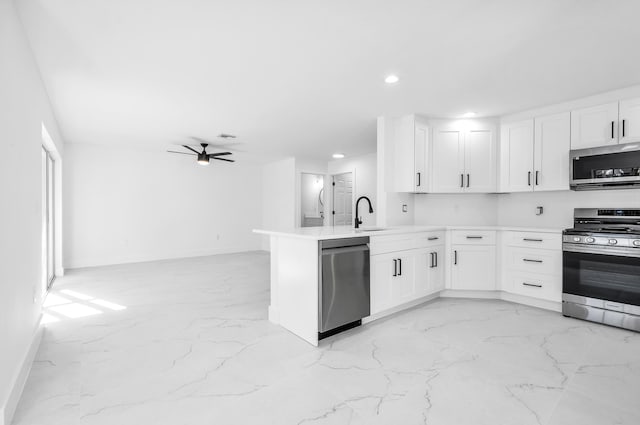 kitchen with kitchen peninsula, stainless steel appliances, white cabinets, and ceiling fan