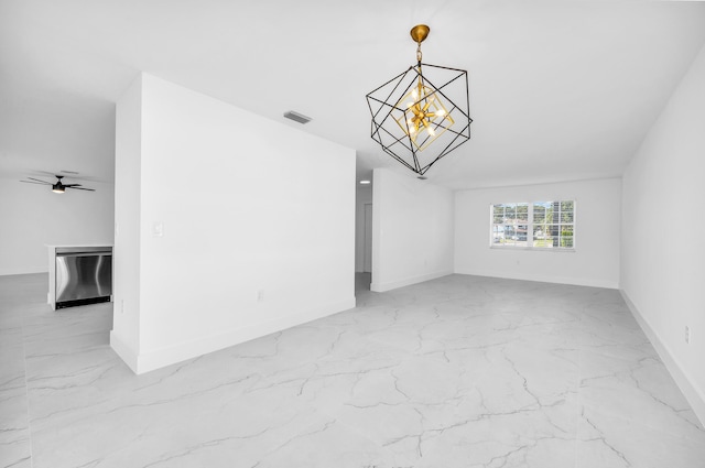 empty room featuring ceiling fan with notable chandelier