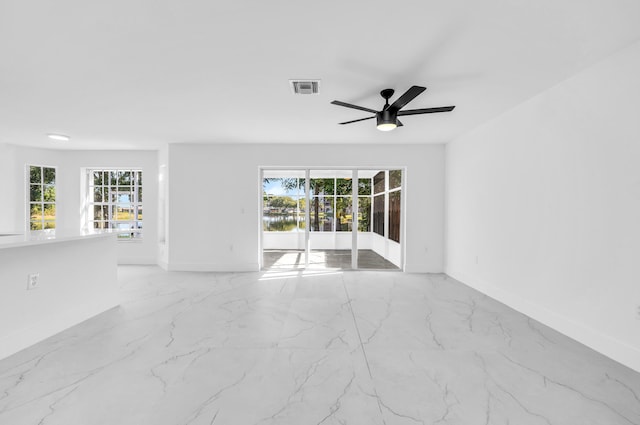 spare room with ceiling fan and plenty of natural light