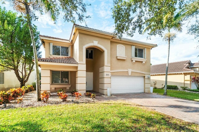 mediterranean / spanish-style house featuring a garage and a front lawn