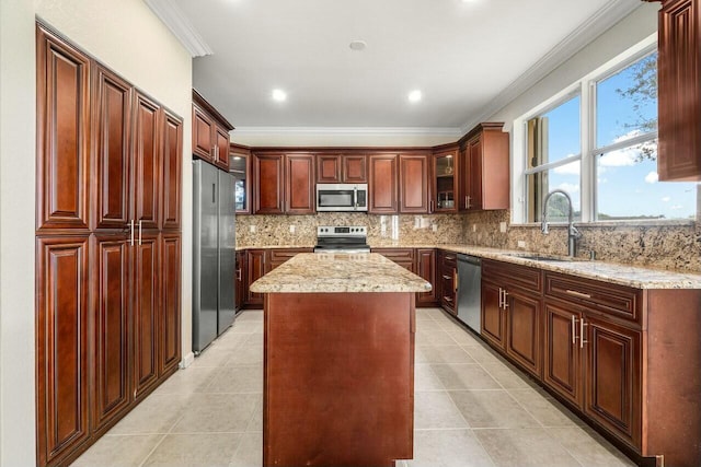 kitchen with a center island, crown molding, sink, appliances with stainless steel finishes, and light stone counters