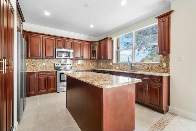 kitchen featuring light tile patterned flooring, crown molding, sink, a kitchen island, and stainless steel appliances