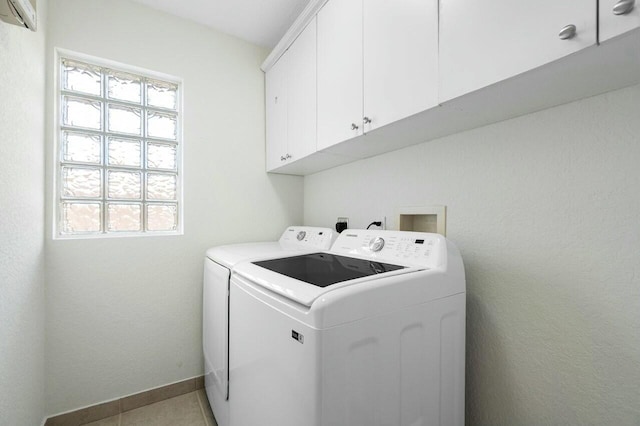 washroom with cabinets, light tile patterned floors, an AC wall unit, and washing machine and clothes dryer